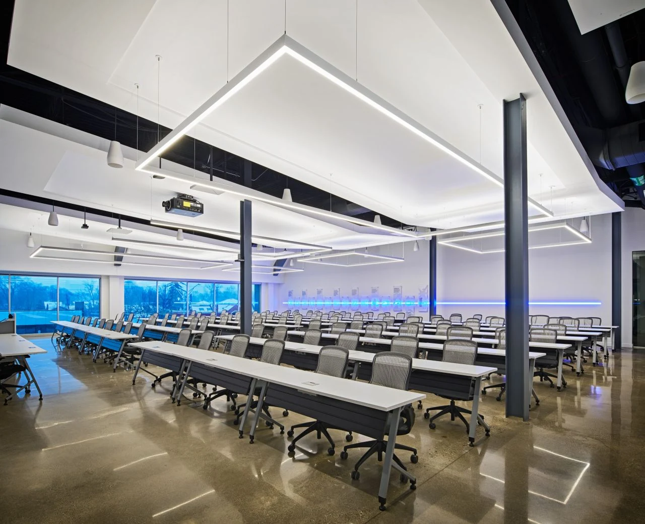Large corporate training room with flexible seating, ceiling projection and integrated audio