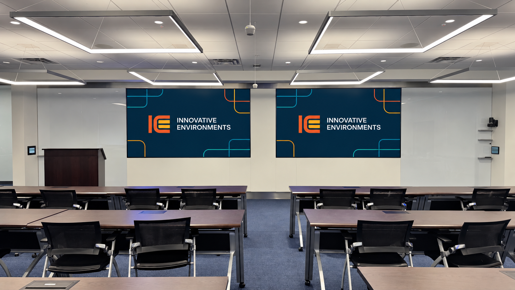 Training room viewed from the seating area toward two presentation displays
